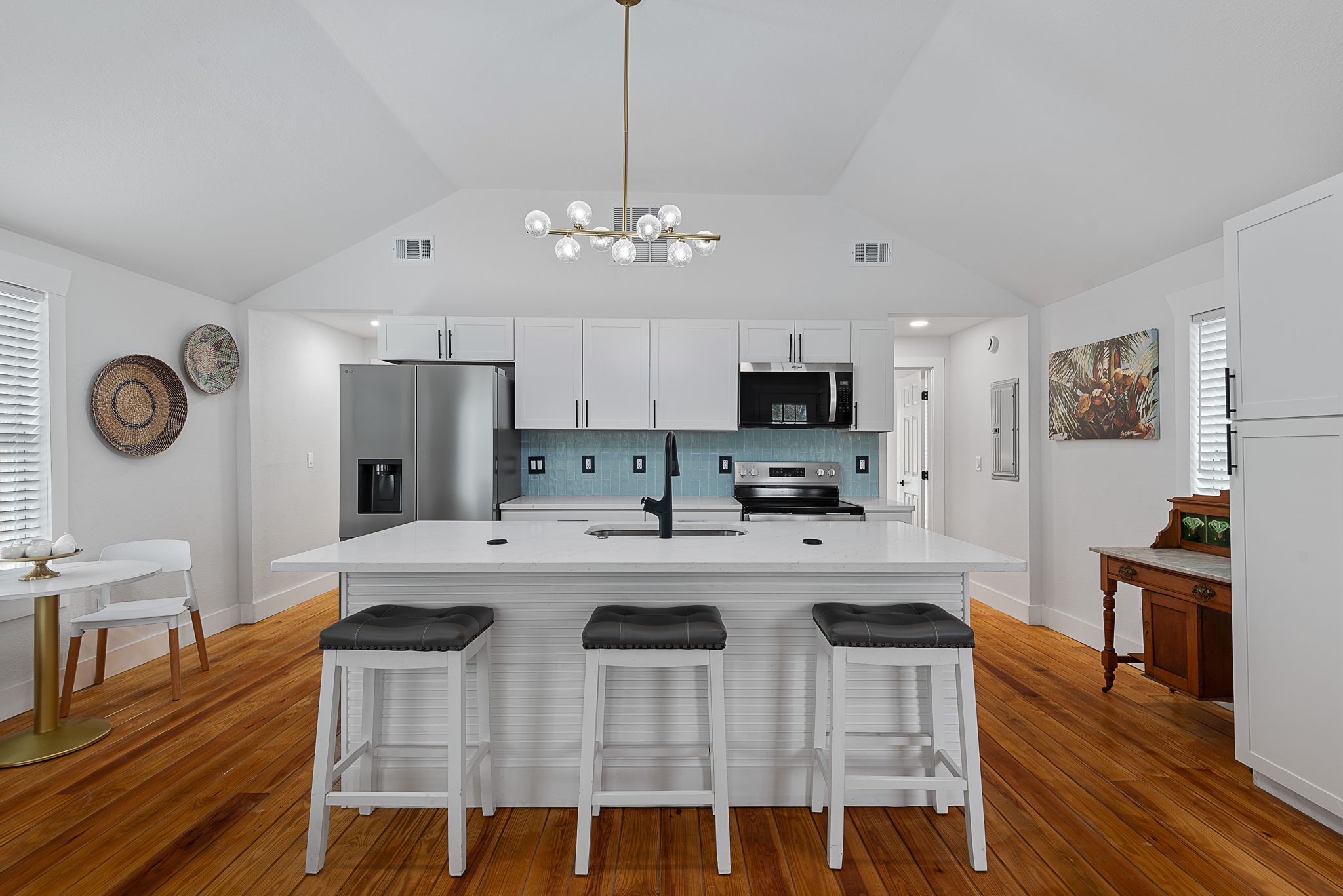 Renovated kitchen with butcher-block island and coastal-blue backsplash